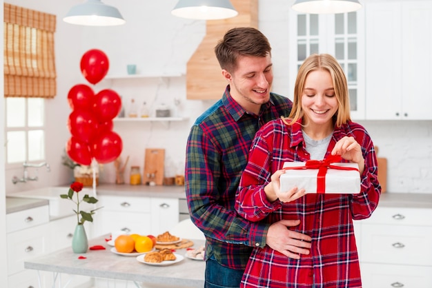 Free photo front view happy woman opening present