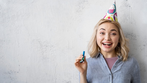 Front view of happy woman with party hat and copy space