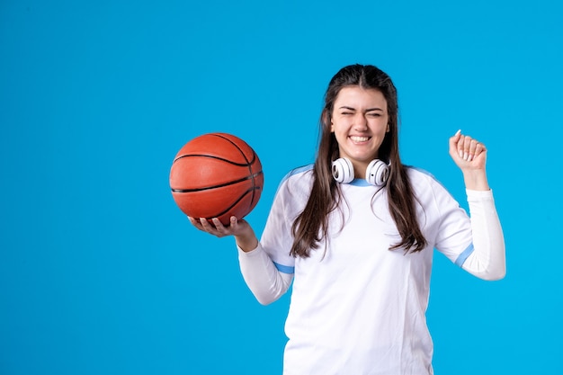 Front view happy young female with basketball