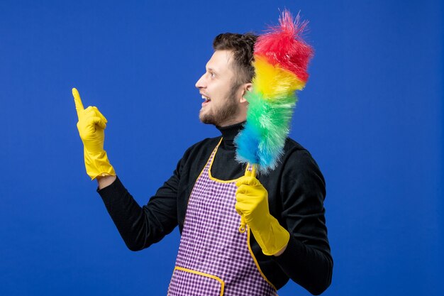 Front view happy young man holding duster 