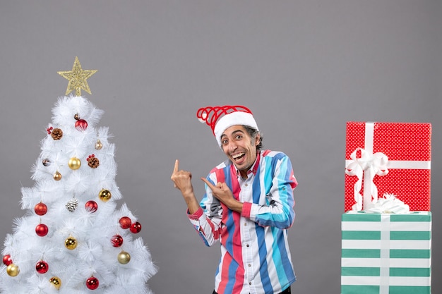 Front view happy young man showing white xmas tree