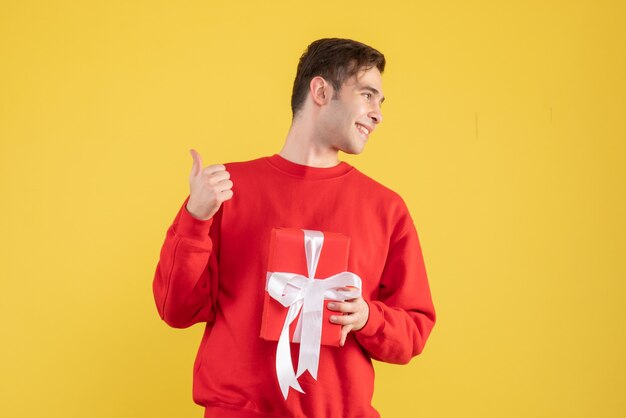 Front view happy young man standing on yellow 