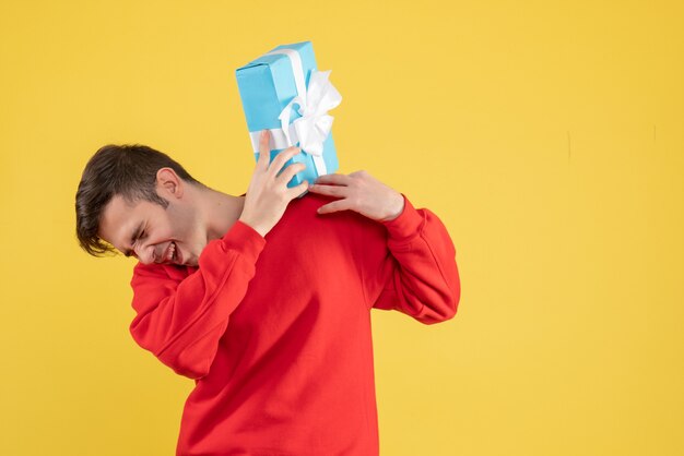 Free photo front view happy young man with red sweater standing on yellow