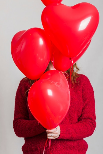 Front view heart balloon covering woman face