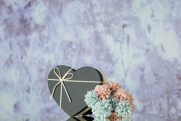 Front view heart box with black cover colored flowers on grey abstract background with free space