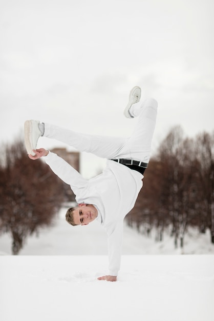 Front view of hip hop performer posing on one hand