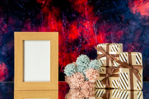 Бесплатное фото Вид спереди праздничные подарки пустая рамка для фотографий на темно-красном фоне