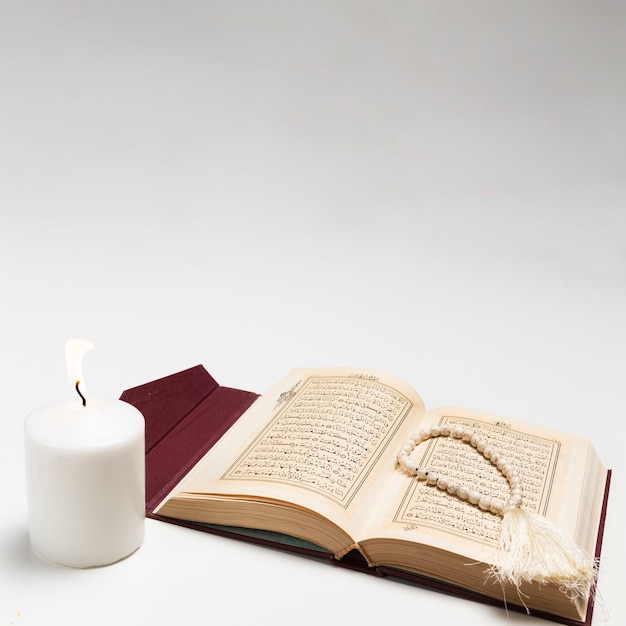 Front view holy book with lit candle