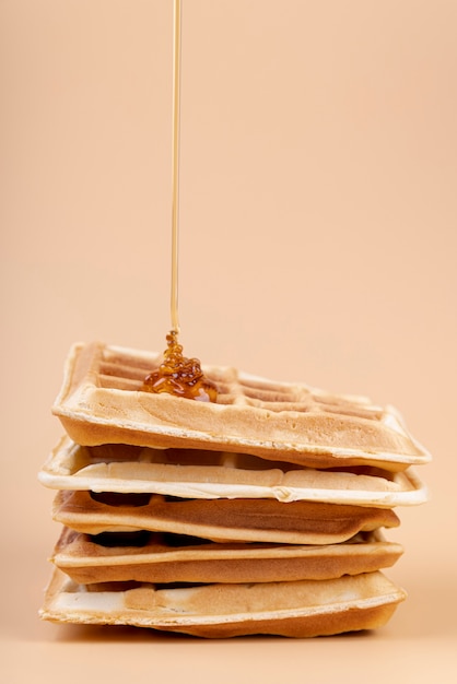 Front view of honey dripping on stack of waffles