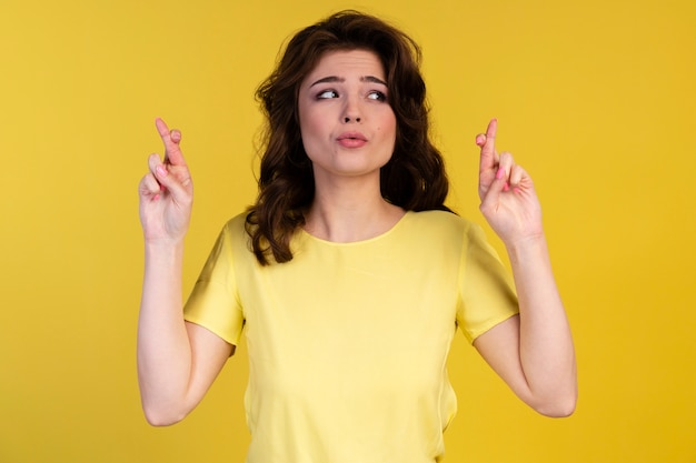 Front view of hopeful woman with fingers crossed