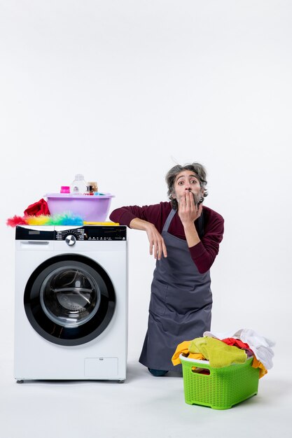 Front view housekeeper man standing on knee bblowing kiss on white background