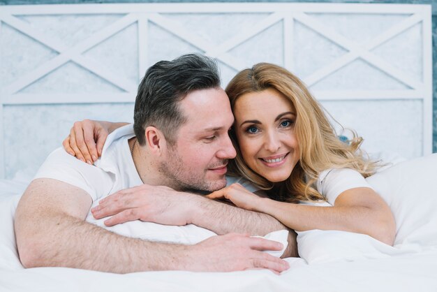 Front view of husband and wife lying on bed