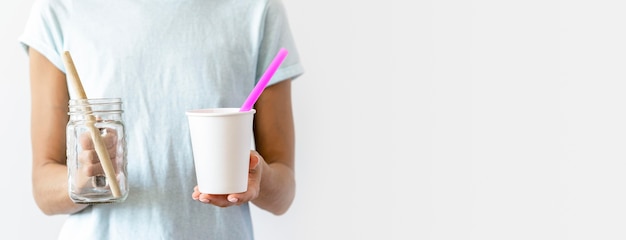 Front view individual holding plastic cups with copy space