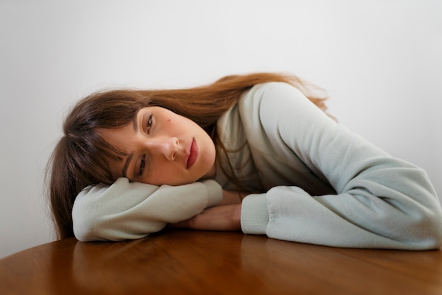 Front view insecure woman with head on table