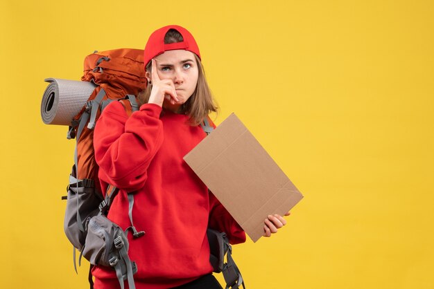 Front view interested female hitchhiker holding blank cardboard