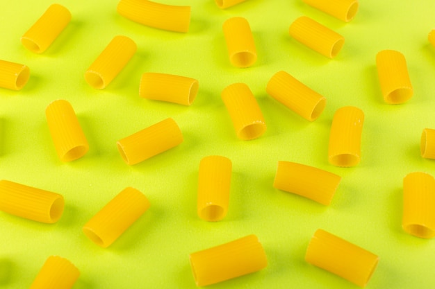 正面は黄色のパスタを緑の背景食品生スパゲッティパスタに少し生を分離