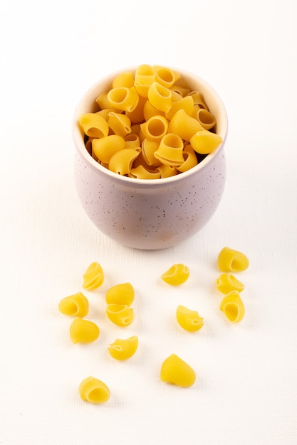 A front view italian dry pasta raw yellow pasta inside bowl on the white
