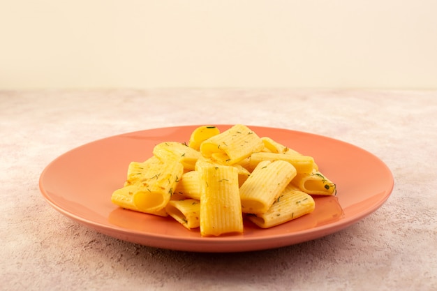 A front view italian pasta tasty meal with dried green herbs inside pink plate on pink