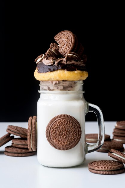 Front view of jar of dessert with biscuits and donut on top