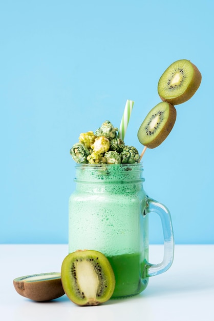 Front view of jar of dessert with kiwi and candy