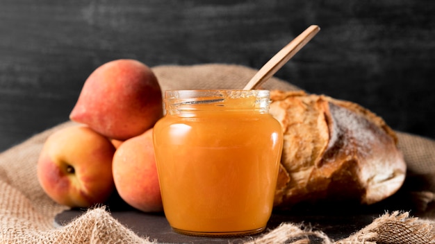 Front view of jar with peach jam and bread