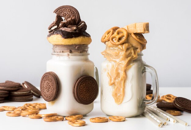 Front view of jars of dessert with biscuits and pretzels