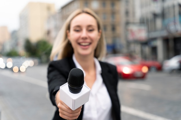 Бесплатное фото Журналист, вид спереди, держит микрофон