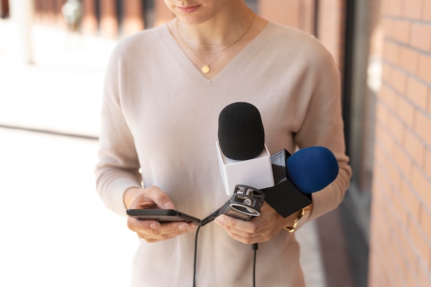Front view journalist holding a microphone