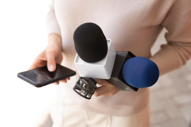 Front view journalist holding a microphone