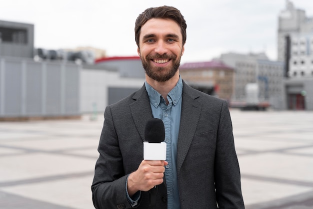 Front view journalist holding a microphone