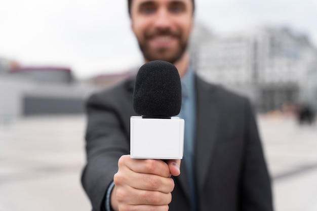 Front view journalist holding a microphone