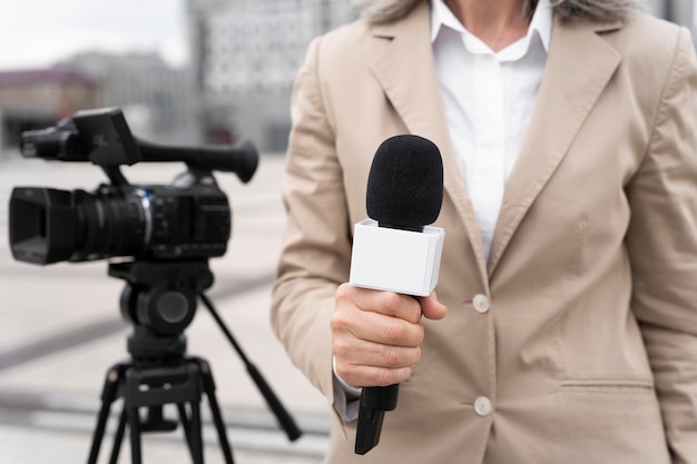 Журналист, вид спереди, держит микрофон
