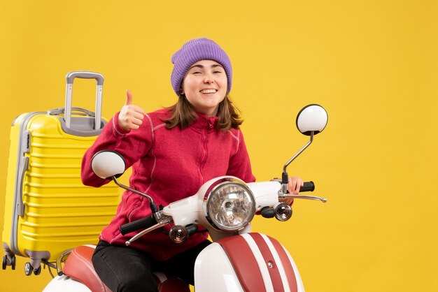 Front view joyful young woman on moped giving thumbs up