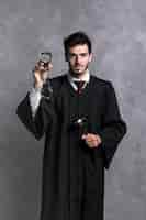 Free photo front view judge in robe with handcuffs and gavel