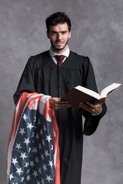Free photo front view judge with flag and opened book