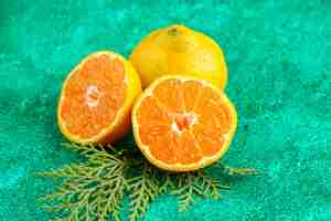 Foto gratuita vista frontale succosi mandarini freschi su sfondo verde colore frutta esotica foto di agrumi acida