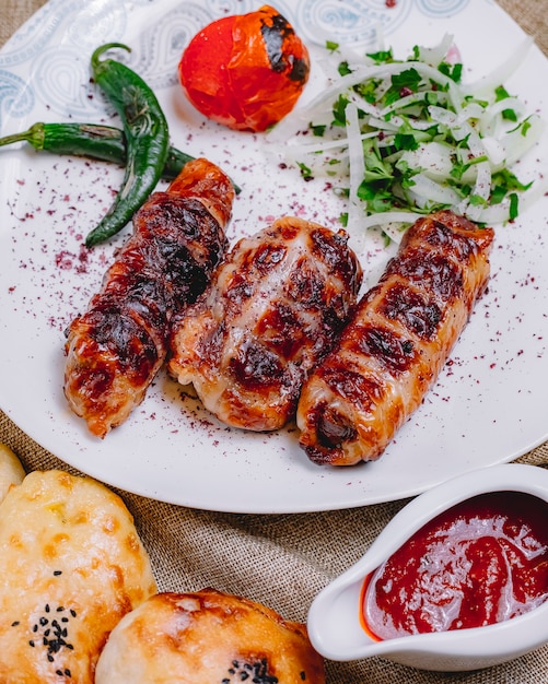 Front view khan kebab with grilled hot pepper and tomato with onions and herbs