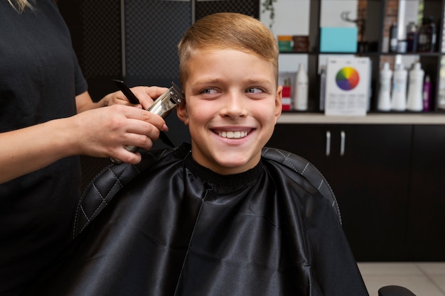 Free photo front view kid getting haircut at salon