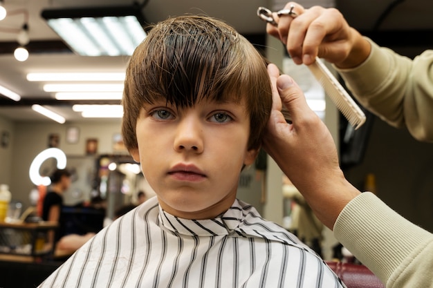 Ragazzo di vista frontale che si fa tagliare i capelli