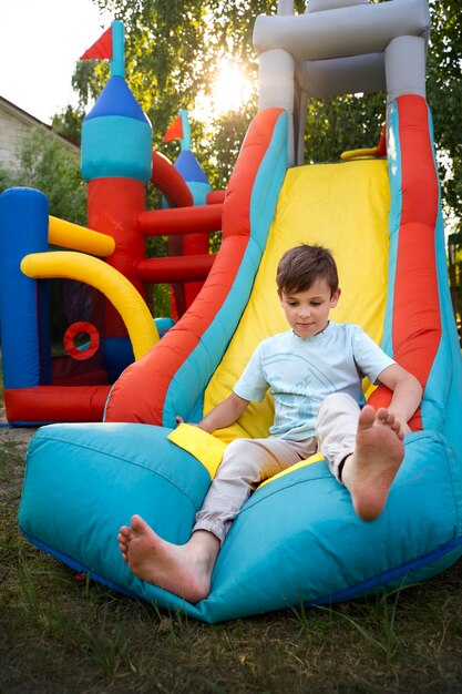 Front view kid having fun in bounce house