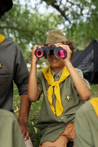 Front view kid holding binoculars