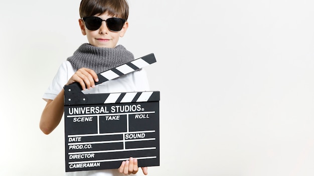 Free photo front view kid holding clapperboard