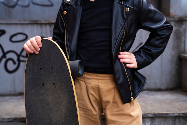 Free photo front view kid holding skateboard