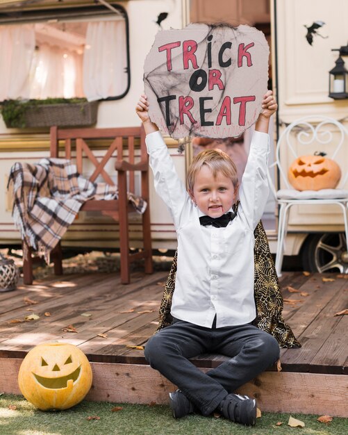 Front view kid holding trick or treat sign