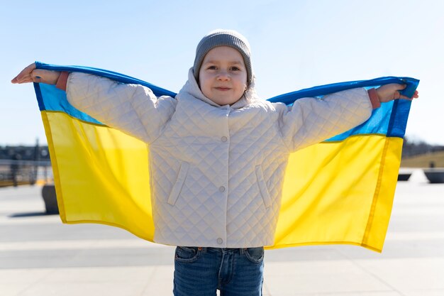 front view kid holding ukrainian flag
