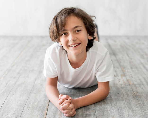 Front view kid laying on floor