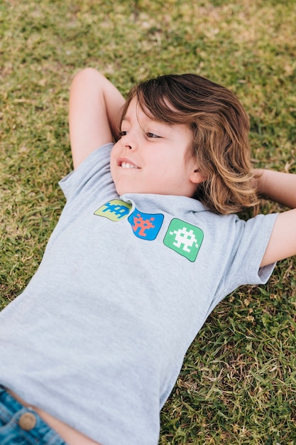 Free photo front view of kid lying on grass