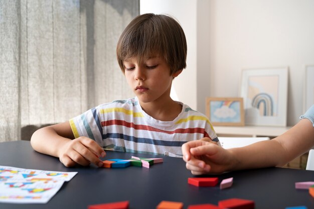 Front view kid making puzzle on table