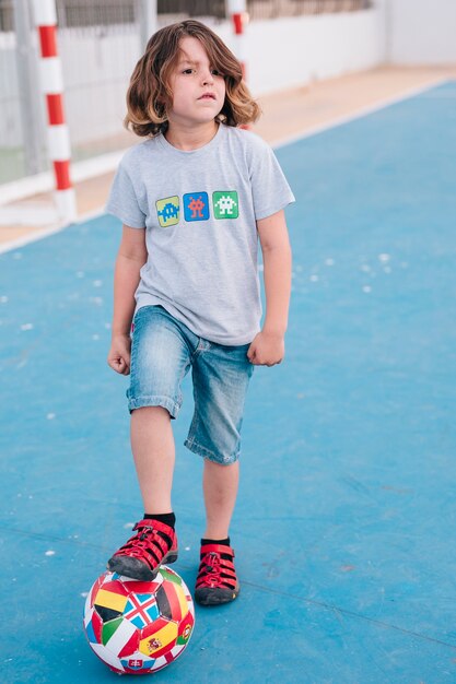 Front view of kid playing with ball