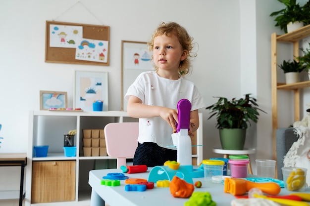 Foto gratuita bambino di vista frontale che gioca con il giocattolo